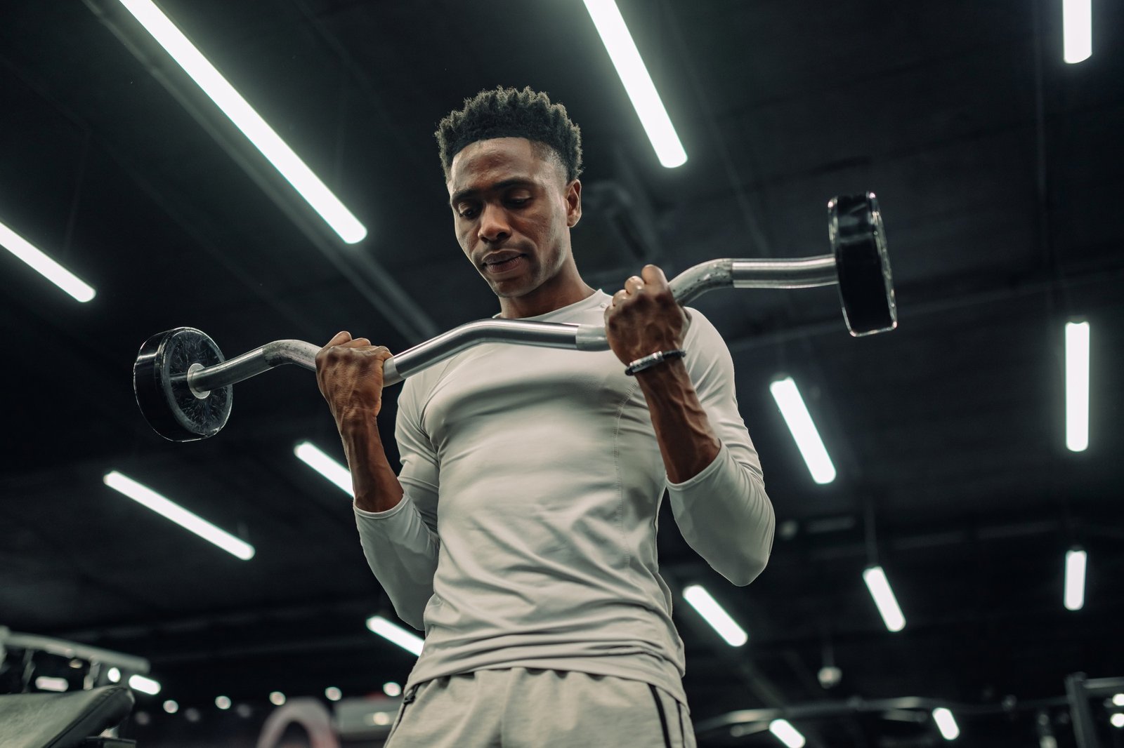Determined athlete lifting weights, building muscles in gym